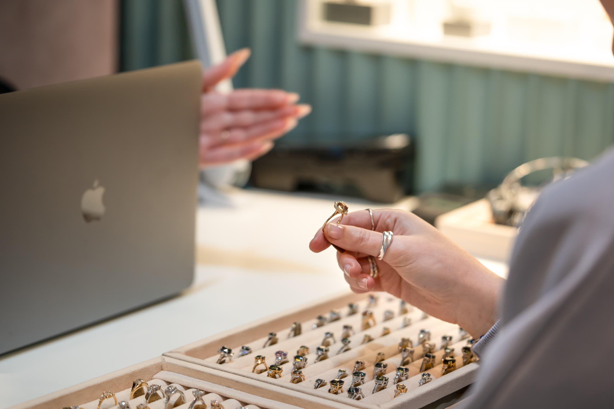 A consultation desk at the Aardvark Jewellery studio with ring trays and a laptop