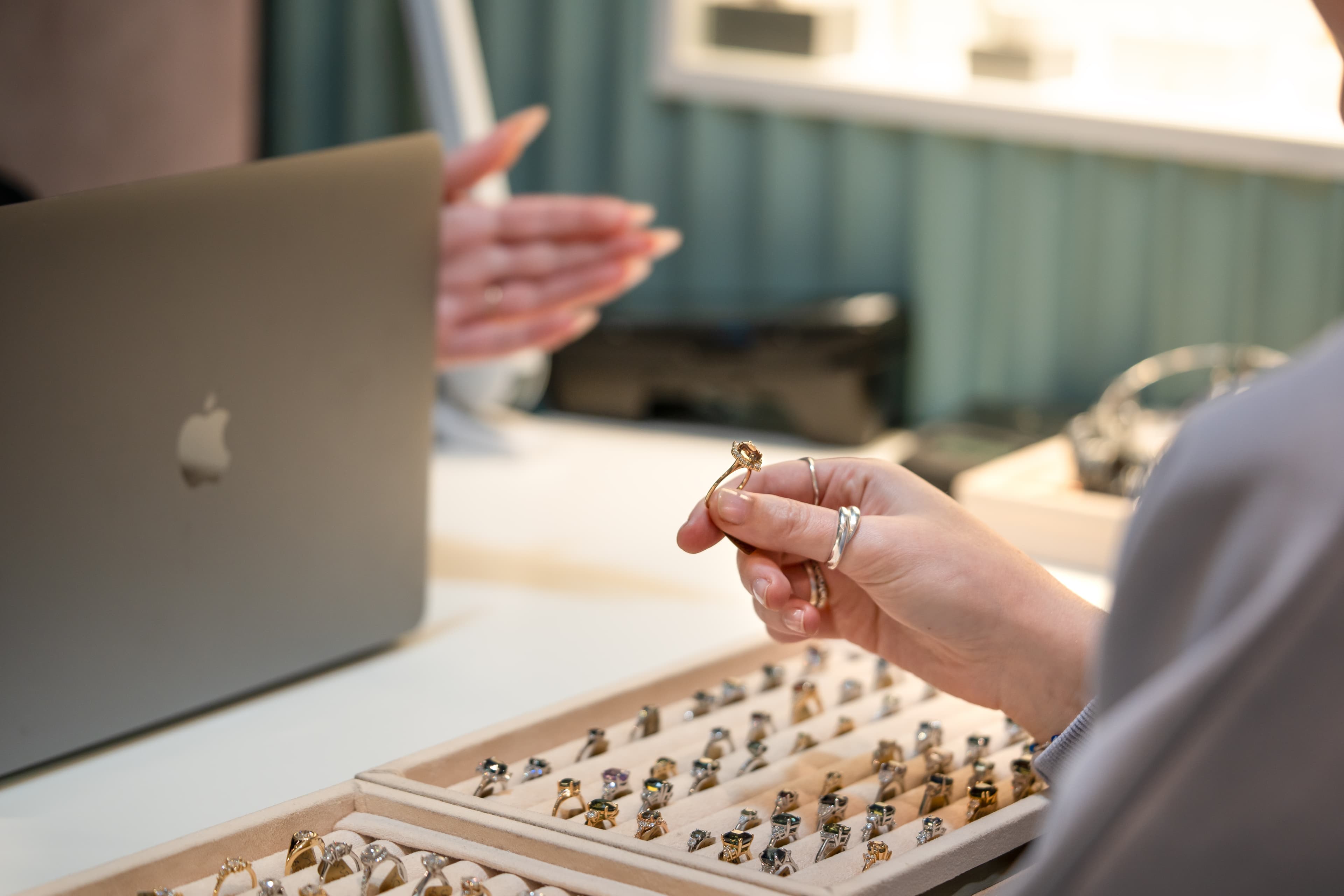 A consultation desk at the Aardvark Jewellery studio with ring trays and a laptop