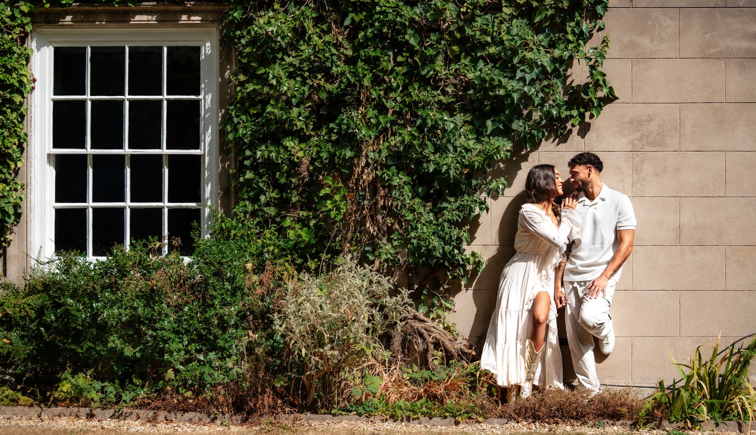 A couple wearing Aardvark rings outside an ivy-covered stone building