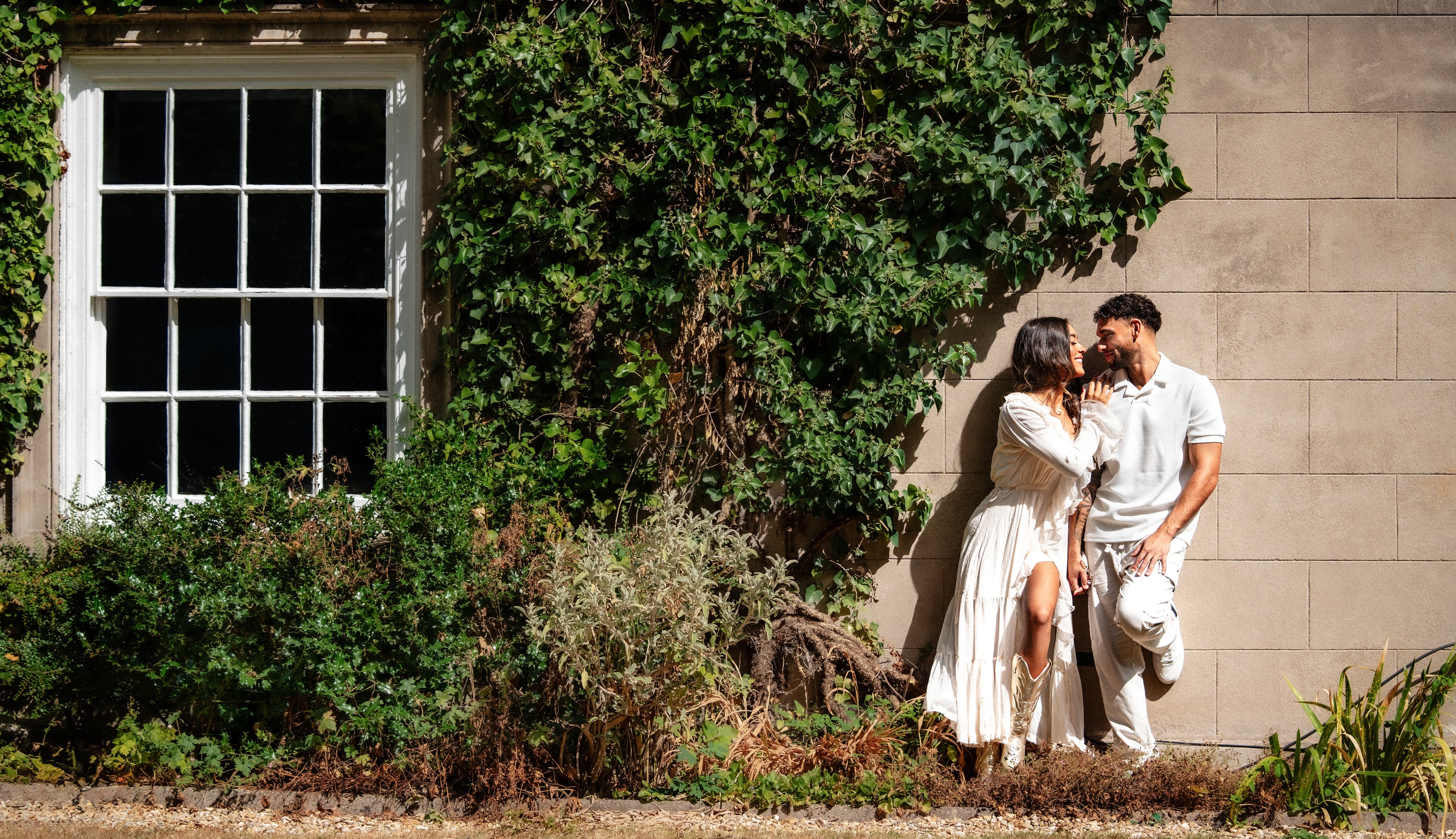A couple wearing Aardvark rings outside an ivy-covered stone building